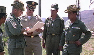 At the Guatemalan Army Counterinsurgency School in 1965, U.S. military advisers confer as Col. Carlos Arana Osorio (right) looks on.