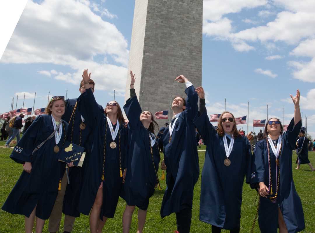 Graduates throwing caps in front of Washington Monument
