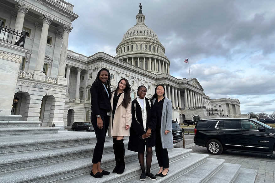 Four female students on the steps at the Capitol building