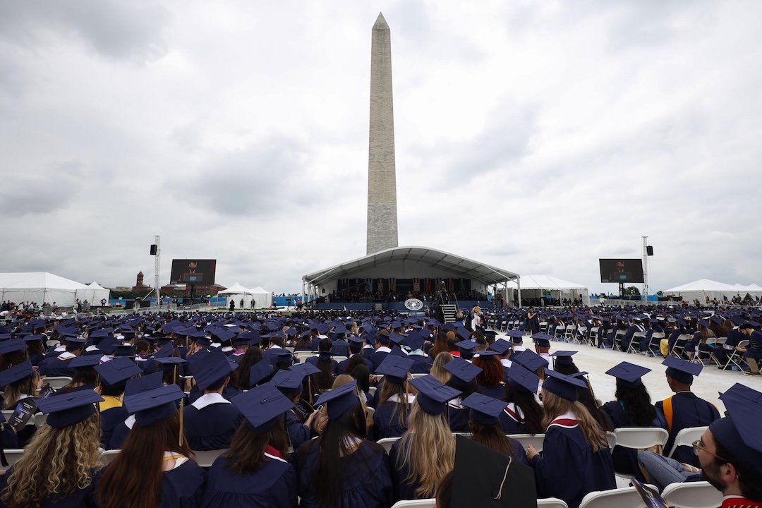 Graduates seated by the Washington Monument at Commencement on the National Mall