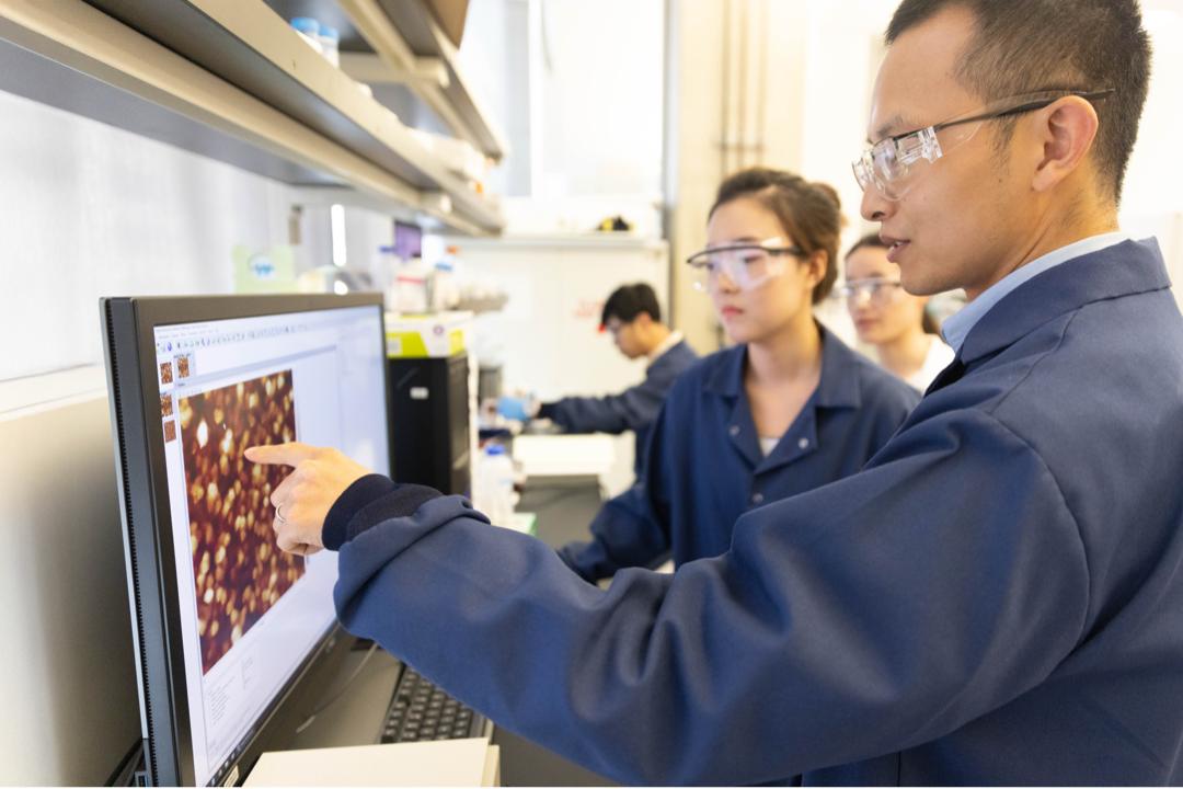 Researchers look at a computer screen