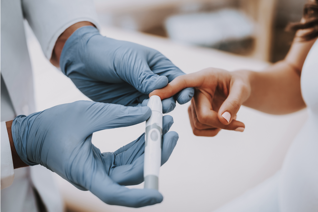 A doctor pricks a patient's finger